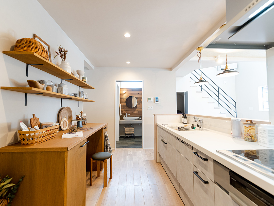 白い石目調のキッチンとおしゃれな造作カップボード