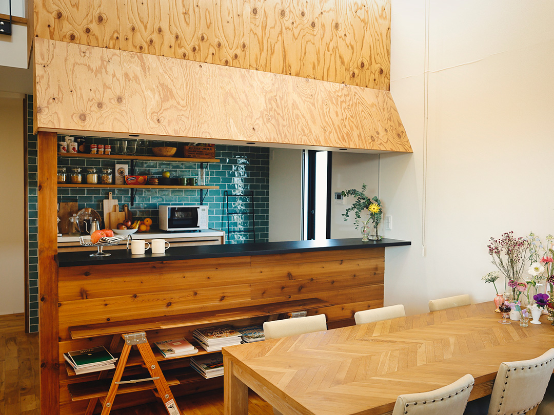 鮮やかな緑のタイルと店舗なようなデザインのアメリカンキッチン